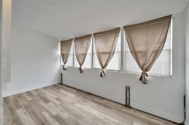 spare room featuring light wood-type flooring and baseboards