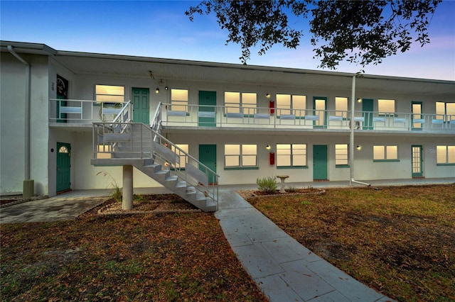 view of property with stairway and stucco siding