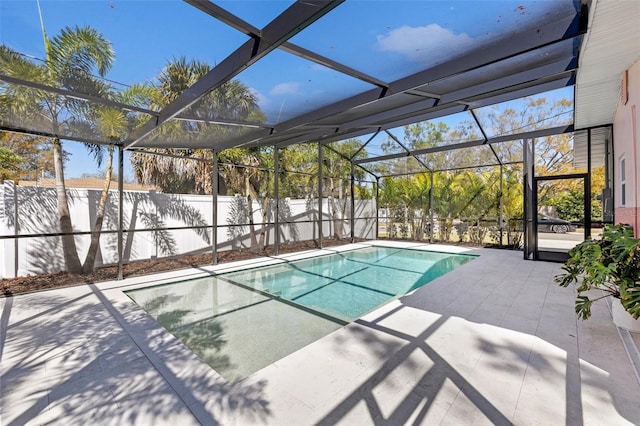 view of swimming pool featuring a patio area, glass enclosure, and a fenced in pool