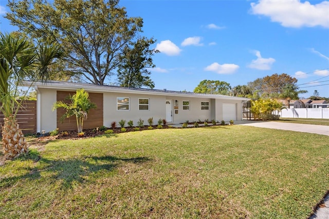 ranch-style home featuring driveway, an attached garage, fence, a front lawn, and stucco siding