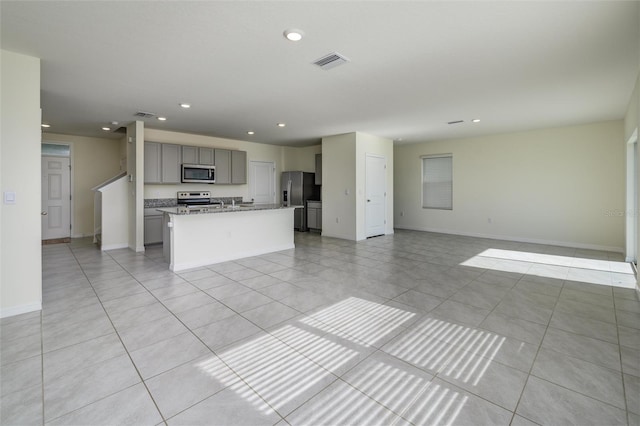 kitchen featuring visible vents, appliances with stainless steel finishes, gray cabinets, and open floor plan