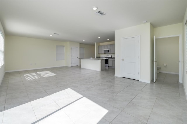 unfurnished living room featuring light tile patterned flooring, recessed lighting, visible vents, and baseboards