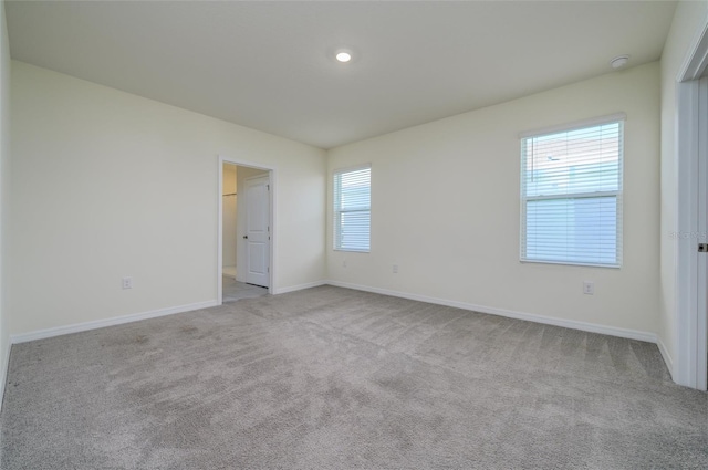 carpeted spare room featuring baseboards