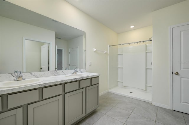 bathroom with tile patterned flooring, double vanity, a sink, and walk in shower