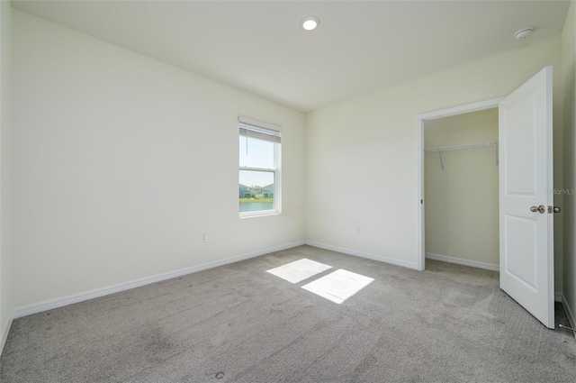 unfurnished bedroom with a closet, baseboards, and carpet flooring