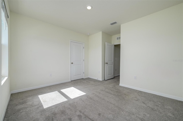 unfurnished bedroom with recessed lighting, carpet, visible vents, and baseboards