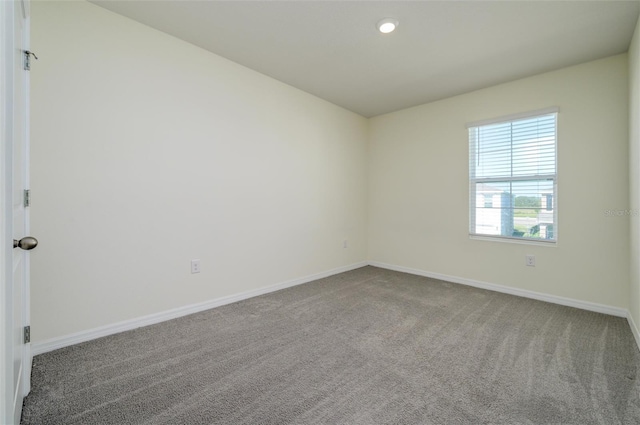 empty room with carpet floors, recessed lighting, and baseboards