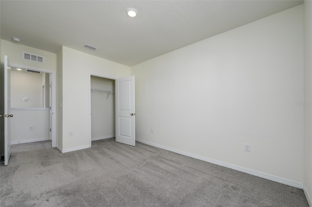 unfurnished bedroom featuring a closet, carpet flooring, visible vents, and baseboards