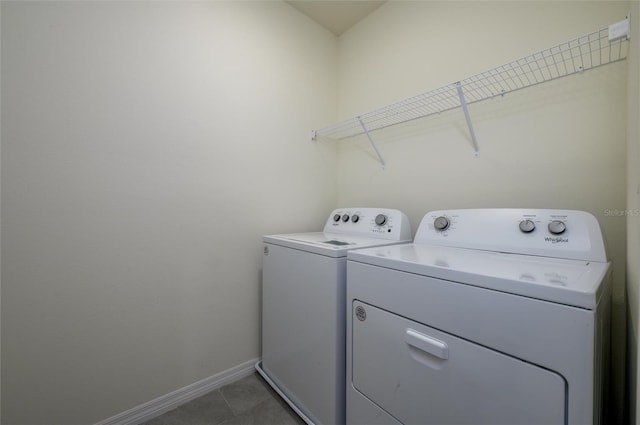 clothes washing area with laundry area, baseboards, separate washer and dryer, and light tile patterned flooring