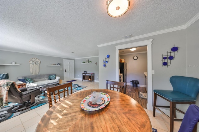 dining room featuring a textured ceiling, light tile patterned flooring, visible vents, and crown molding