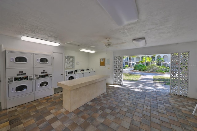 common laundry area featuring stacked washing maching and dryer, ceiling fan, washer and clothes dryer, and a textured ceiling