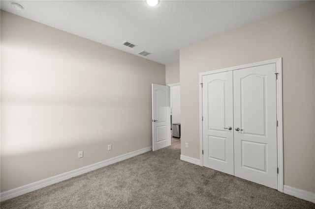 unfurnished bedroom featuring carpet, visible vents, a closet, and baseboards