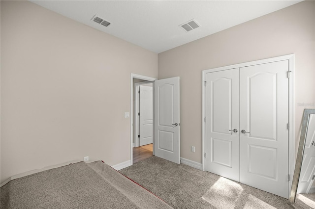 unfurnished bedroom with visible vents, baseboards, carpet, and a closet