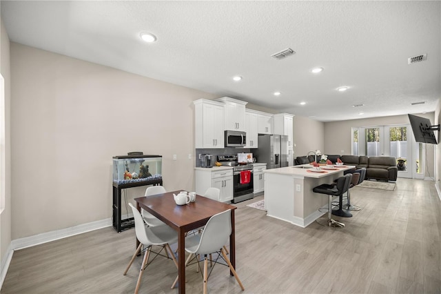 dining area with recessed lighting, visible vents, light wood-type flooring, and baseboards