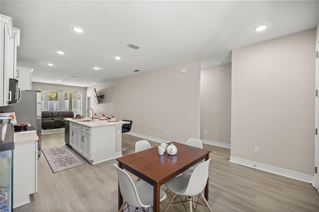 dining area featuring light wood-style flooring, recessed lighting, baseboards, and visible vents