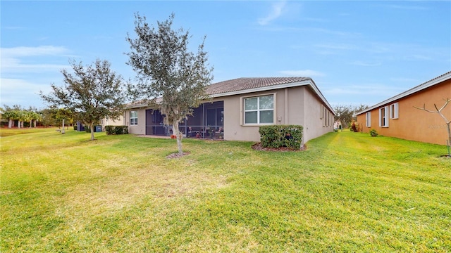 back of property with a yard and stucco siding