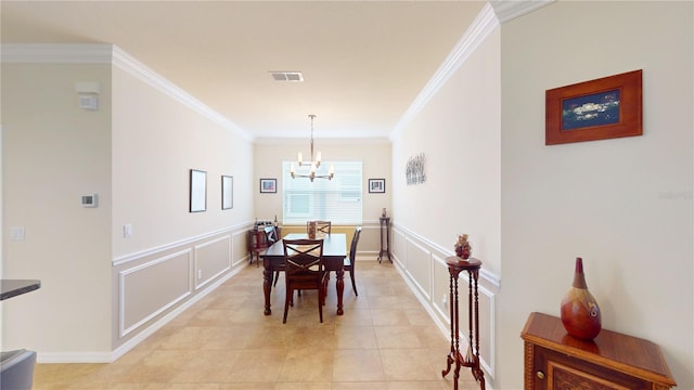 dining space featuring crown molding, visible vents, a decorative wall, and a notable chandelier