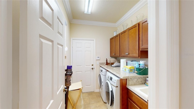 clothes washing area featuring light tile patterned floors, ornamental molding, washer and clothes dryer, and cabinet space