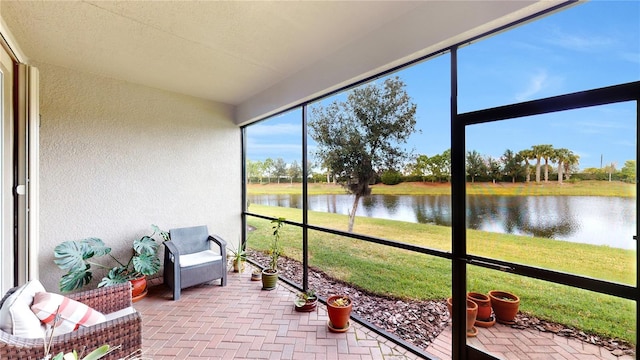 sunroom / solarium featuring a water view