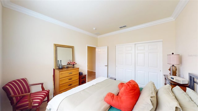 bedroom featuring a closet, visible vents, and crown molding