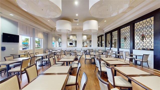 dining area with a tray ceiling, hardwood / wood-style floors, visible vents, and recessed lighting