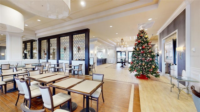 dining area with visible vents, ornamental molding, a tray ceiling, a chandelier, and a decorative wall