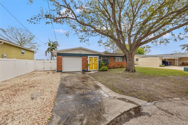 single story home with an attached garage, brick siding, fence, driveway, and a gate