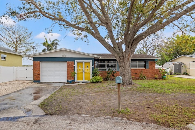 single story home featuring a garage, brick siding, fence, driveway, and a gate