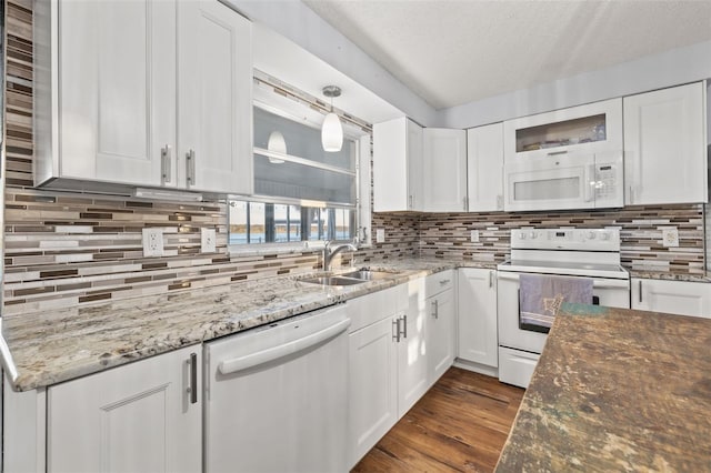 kitchen with white appliances, white cabinets, and a sink