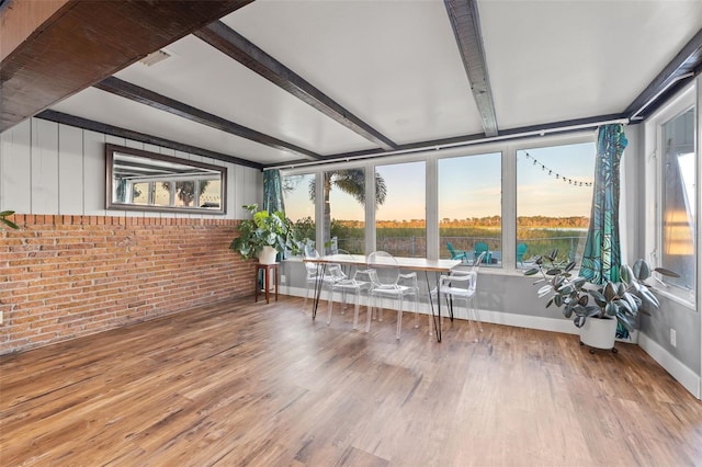 sunroom / solarium featuring beamed ceiling and visible vents