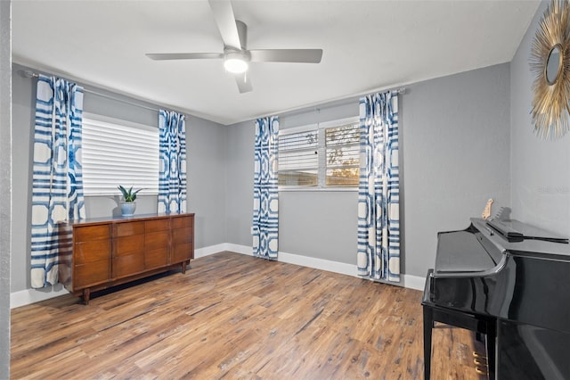 home office with ceiling fan, baseboards, and wood finished floors