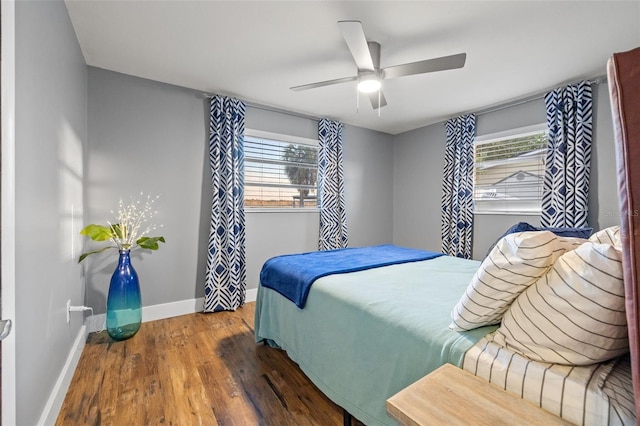 bedroom with wood finished floors, a ceiling fan, and baseboards