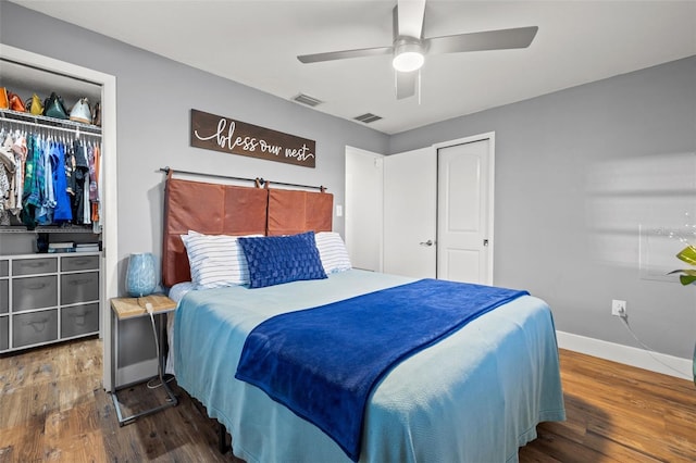 bedroom featuring a closet, visible vents, baseboards, and wood finished floors