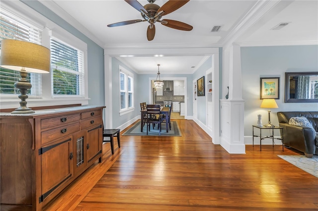 dining room with light wood-style flooring, visible vents, baseboards, and ornamental molding