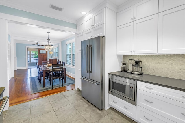 kitchen with stainless steel appliances, dark countertops, visible vents, backsplash, and white cabinets