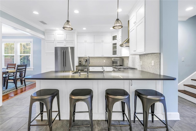 kitchen with crown molding, stainless steel appliances, dark countertops, visible vents, and a sink