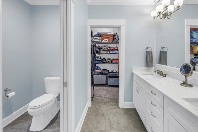 bathroom featuring a spacious closet, double vanity, a sink, and toilet