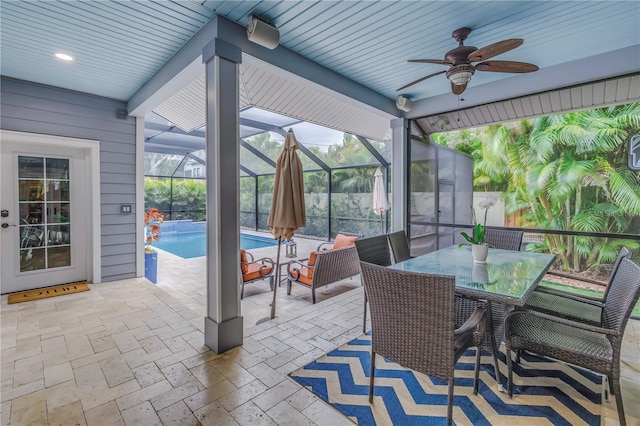 view of patio / terrace with an outdoor pool, outdoor dining space, a lanai, and ceiling fan