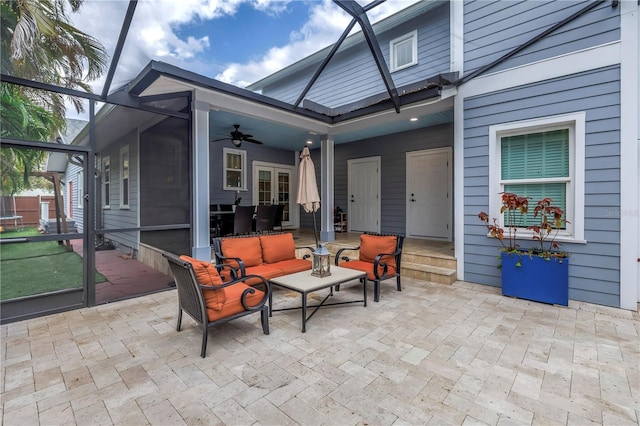 view of patio / terrace featuring ceiling fan, glass enclosure, and an outdoor living space