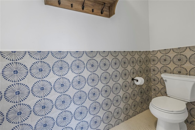 bathroom with toilet, tile patterned flooring, and wainscoting