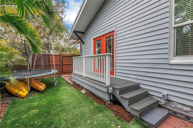 view of yard featuring a trampoline and fence