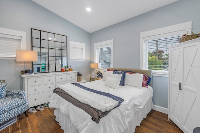 bedroom featuring lofted ceiling, wood tiled floor, multiple windows, and baseboards