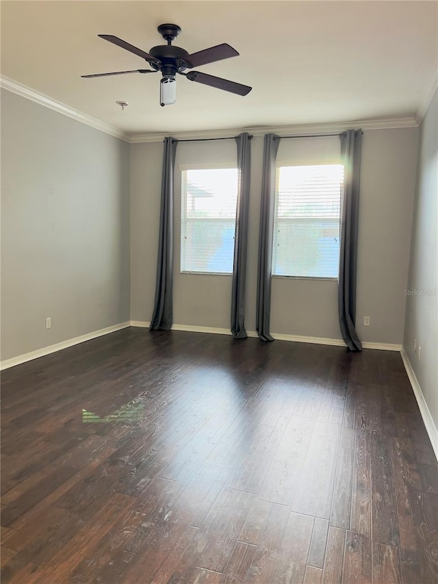 empty room featuring ornamental molding, dark wood finished floors, baseboards, and ceiling fan