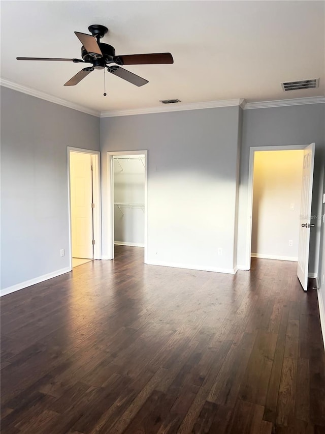 unfurnished room featuring baseboards, dark wood-type flooring, and crown molding