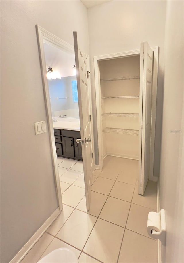 hall with baseboards and light tile patterned flooring