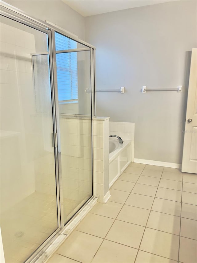 full bath with a stall shower, tile patterned flooring, baseboards, and a bath