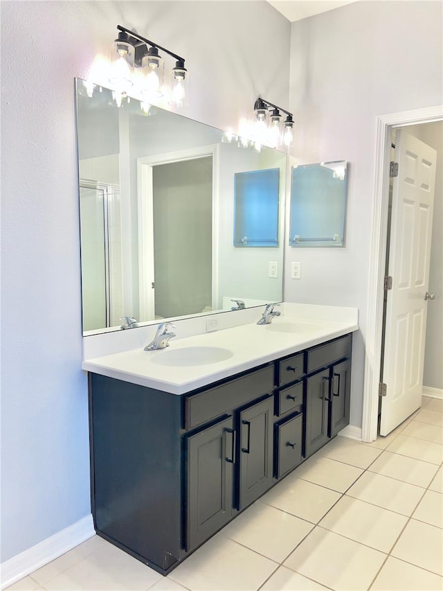 bathroom featuring double vanity, baseboards, a sink, and tile patterned floors