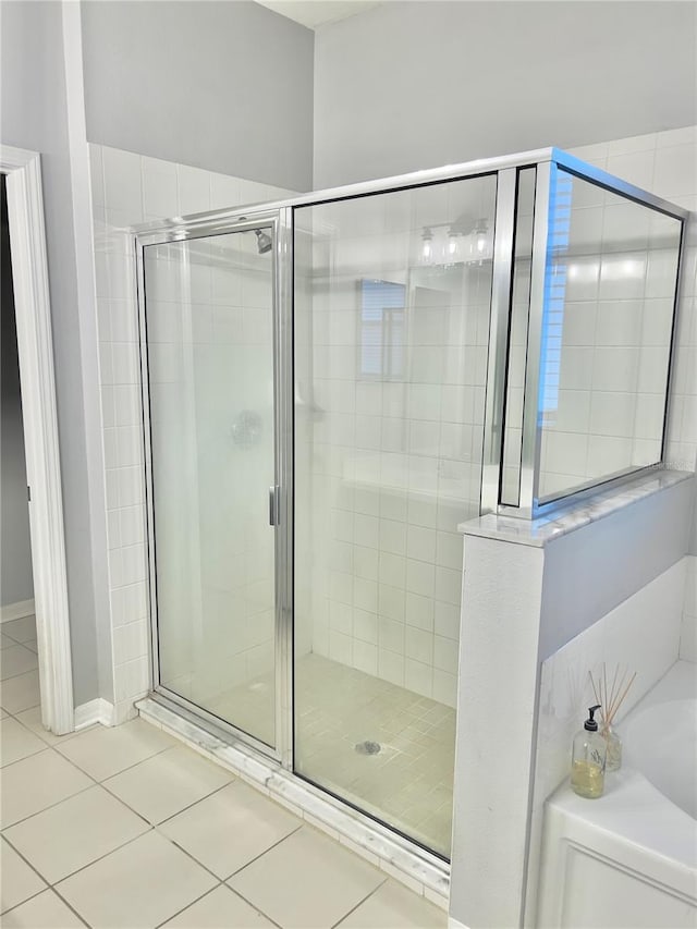 full bathroom with tile patterned flooring, a bath, and a shower stall