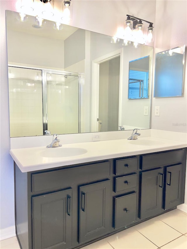 bathroom with tile patterned floors, a sink, a shower stall, and double vanity