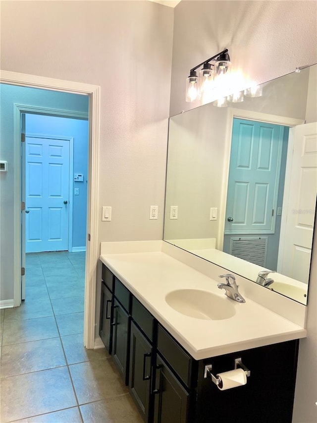 bathroom featuring baseboards, visible vents, vanity, and tile patterned floors